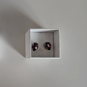 Caroline Svedbom Petite Earrings Iris Rhodium - Caroline Svedbom Petite Drop Earrings Iris Rhodium i oanvänt skick komplett med ask  Storlek: 7 x 5 mm Plätering: 18K Guld / Rodium Världens högsta kvalitet på kristaller  Jag säljer även ett matchande halsband i en annan annons så kika gärna på den.