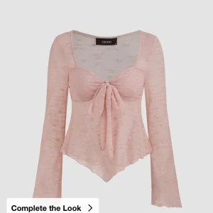 Ljusrosa blus med knyt från Cider - Supersöt ljusrosa blus från Cider med långa ärmar och knyt framtill. Toppens material är lätt och transparent med subtila blommiga detaljer. Den har en v-ringad urringning. Originalpris 276kr