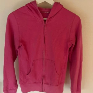 Rosa hoodie med dragkedja från H&M - Enkel och snygg rosa hoodie från H&M i storlek 158/164. Mycket bra skick!!💓 Tröjan har huva, dragkedja framtill och två stora fickor. 