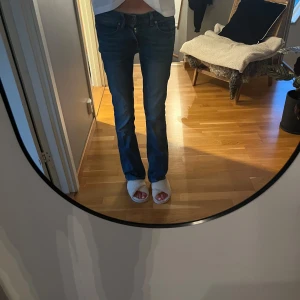 G-Star RAW Midge Bootcut jeans blå - Säljer ett par blå G-Star RAW Midge Bootcut jeans med klassisk femficksdesign och snygga kontrastsömmar. Jeansen har bootcut-ben och låg midja, tillverkade i slitstarkt bomullsjeans. Perfekta för dig som gillar en tidlös och avslappnad look. Jeansen har en slitning på ena fickan. Midjemått: 36, Innerbenslängd: 80 cm🩷