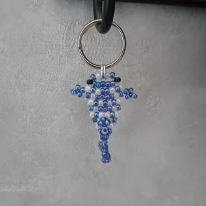 Nyckelring valhaj - Nyckelring med handgjord valhaj i blå och vita skimmrande pärlor. Perfekt som accessoar till väskan eller nycklarna. Valhajen är ca 4cm lång 