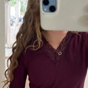 Vinröd långärmad topp med spets - En jättefin vinröd långärmad tröja med spets vid halsen. Obs det är spegeln som är smutsig på andra bilden inte tröjan, bevis på fjärde bilden. Bra till vardagen eller jul. Från Gina tricot young.  Väldigt mjuk och gosig.🥰