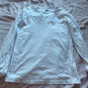 Vit långärmad basic tröja H&M - En enkel och clean vit långärmad tröja från H&M Basic, gjord i mjuk ekologisk bomull. Perfekt för lager-på-lager och chill dagar. Rund hals och normal passform, passar dig som gillar minimalistisk stil.