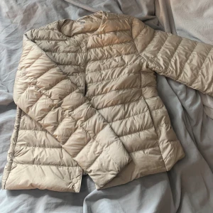 Beige dunjacka från Uniqlo XS - Säljer en beige, tunn dunjacka från Uniqlo i storlek XS! 