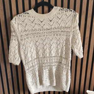 Beige stickad topp från Zara - Sista bilden visar hur den ser ut på!!Säljer en beige stickad topp från Zara i storlek S. Tröjan har ett snyggt hålmönster med zigzag-detaljer och rund hals. Ärmarna är trekvart. Också använd 2-3 gånger. Köpt för 400 ungefär💕💕 