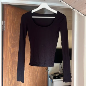 Svart långärmad topp med slits - En svart långärmad topp med slits från Gina tricot, storlek xs, använd ksk 1-2 gånger