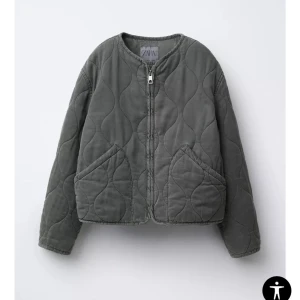 Grön/ grå jacka från Zara - Grön/ grå jacka från Zara med rund halsringning och dragkedja framtill. Jackan har två stora fickor och ett vågigt quiltat mönster som ger en cool vibe. Perfekt för lager-på-lager och chill höstoutfits.