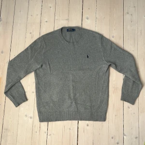 Stickad Polo Ralph Lauren-tröja  - Stickad gråmelerad tröja i bomull från Polo Ralph Lauren. 