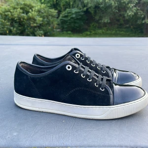 Lanvin patent cap toe sneakers - Säljer nu dessa riktigt snygga Lanvins i storlek UK 7 vilket motsvarar 40-42 ungefär 🙌 Mockan är i nästintill perfekt skick, sulan är vit och fin. Alla sömmar är intakt osv! Enda defekten är en liten defekt på cap toen på vänster sko, vilket man ej lägger märke till vid första anblick. Skriv vid funderingar 😁 kom gärna med prisförslag🙏