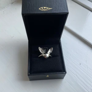 Maria Nilsdotter lovers ring - Unik silverring från Maria Nilsdotter med cool design – ett hjärta med två detaljerade vingar. Ringen är helt ny och kommer i original ask då jag köpte för storlek 