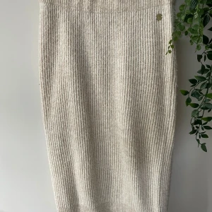 Stickad långkjol - Supermysig beige stickad långkjol med ribbad struktur. Kjolen har en rak passform. Är från Pernilla Wahlgrens kollektion på gåkås. 