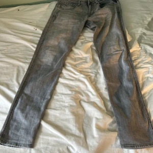 Replay ljusgrå jeans  - Säljer ett par ljusgrå jeans från Replay med klassisk femficksdesign. Jeansen har en snygg tvättad look och svarta detaljer vid sömmarna. Perfekta för dig som gillar en clean och stilren vibe.