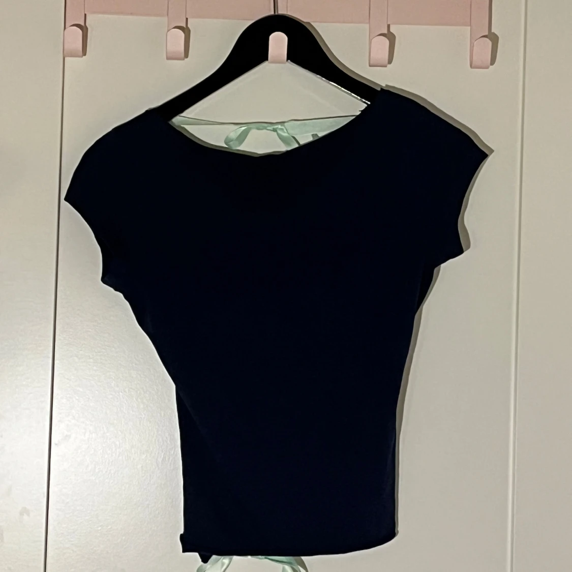 Mörkblå topp med mintgröna rosetter