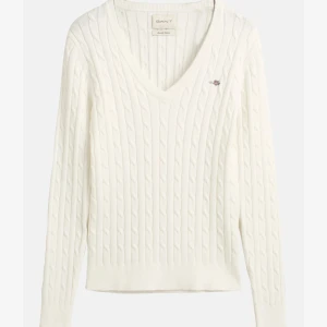 Vit kabelstickad tröja från Gant - Vit kabelstickad v-ringad  tröja från Gant i bra skick. Säljer då jag inte använder längre! Nypris 1600 kronor💞 