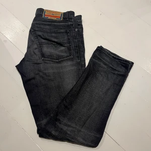 Svarta jeans från Diesel Industry - Snygga svarta jeans från Diesel Industry med klassisk femficksdesign och tydlig läderpatch bak i midjan. Jeansen har en mörk tvätt och raka ben, perfekta för en clean och stilren look. Materialet är slitstarkt denim i bomull.  Storlek: W30. Endast använda ett fåtal gånger. Bara att höra av sig vid eventuella frågor!😉