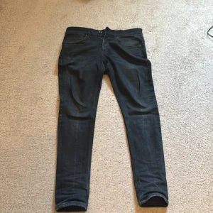 Dondup George , slim fit - Mörk blåa jeans från George i slim fit-modell med klassisk femficksdesign. Jeansen har diskreta slitningar och en något tvättad look. Tillverkade i mjukt denimtyg med stretch för extra komfort. Perfekta för dig som gillar en smalare passform.