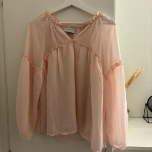 Rosa blus  - Jag säljer en oanvänd blus köpt på eko, blusen är i storlek S men den är väldigt luftig och stor så passar lätt en M också, pris kan diskuteras 