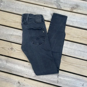 Replay svarta skinny jeans - Snygga svarta skinny jeans från Replay med klassisk femficksdesign och diskreta sömmar. Jeansen har en mörk tvätt och är tillverkade i stretchigt bomullsmaterial för en bekväm passform. Perfekta för dig som gillar en tight och stilren look.