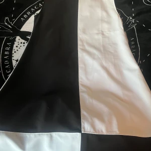 Svartvit kortklänning Love Her Madly - Snygg svartvit kortklänning från Love Her Madly, tillverkad i UK. Klänningen har ett coolt blockmönster med breda svarta och vita paneler framtill. Rak passform och rund halsringning, perfekt för dig som gillar retrostil. 