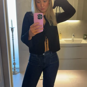 Blå bootcut jeans med fickor - Säljer ett par snygga blå bootcut jeans från Bik Bok. Jeansen har medelhög midja, raka ben med lätt utsvängning och stora fickor både fram och bak. Klassisk denim med kontrastsömmar och bälteshällor. Perfekta för en trendig och avslappnad look. Storlek 27/32