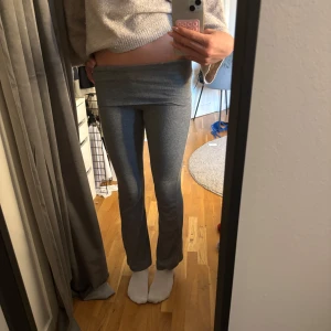 Grå ribbade yoga pants från Gina Tricot - Supersköna grå ribbade byxor från Gina Tricot med utsvängda ben. Mjukt stretchigt material som sitter tajt upptill och är flare där nere. Perfekta för en chill och trendig look. Säljer pga att de är för korta för mig, använda väldigt få gånger men har två vita fläckar på ena benet. De syns dock inte så mycket när de sitter på. 