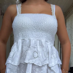 Vit somrig topp med broderi - Supersöt vit topp med volanger. Har två därav till salu den här är aldrig använd.