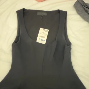 Svart ärmlös blus från Zara - Superfin blus från Zara i ärmlös modell med U ringning! Det finns en dragkedja på sidan. Det är inte permanenta fläckar på utan bara deodorant fläckar som går bort i tvätten! Kan inte tvätta pga att prislappen är kvar, aldrig använd, bara testad!