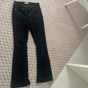 Svarta bootcut jeansbyxor - Snygga svarta jeansbyxor med bootcut-snitt och klassisk femficksdesign. Byxorna har en stilren look och passar perfekt till sneakers eller boots. Materialet är stadigt och ger en schysst passform.