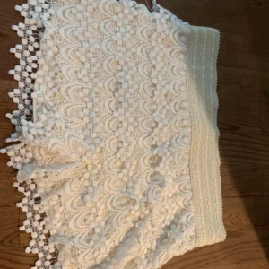 Vita spets-shorts med volangkant - Superfina vita shorts med bred resår i midjan och detaljerad spets över hela plagget. Volangkant nertill ger en extra söt touch. Perfekta för sommarens alla tillfällen och riktigt sköna att bära.