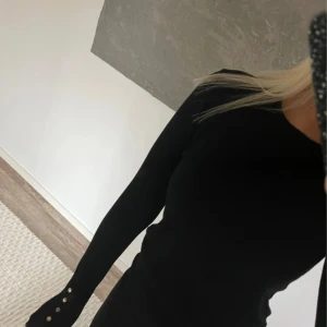 Svart långärmad tröja från Zara - Snygg svart långärmad tröja från Zara med guld knappar på armen i s 