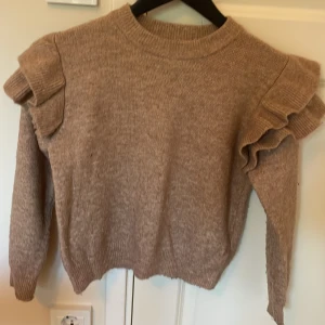 Beige stickad tröja med volangärmar - Stickad tröja från h&m. Jättefin att ha till skolan eller till en fin middag.