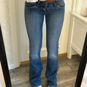 Lågmidjade utsvängda jeans  - Skiit snygga jeans från Lee! De är lite slitna längst ner men inget man tänker mycket på. De är i W27 L35. Innerben: 85 cm, midja rakt över 38 cm Kom privat för fler mått eller frågor🥰