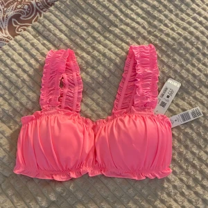 Rosa rynkad bikiniöverdel från Cubus - Supersöt rosa bikiniöverdel från Cubus med breda, rynkade axelband och volangdetaljer. Materialet är mjukt och stretchigt syntet. Den är i ny skick då storleken inte passa. 🩷🩷
