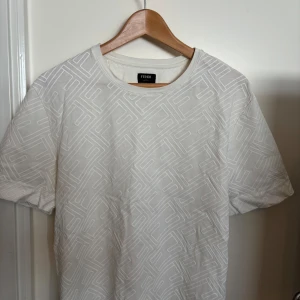 Vit Fendi t-shirt - Säljer en vit t-shirt från Fendi. Ord pris 7800 men säljs för 2900. Det är en present så har tyvärr inget kvitto men man ser klart och tydligt att tröjan är äkta. Den är S men den passar även M