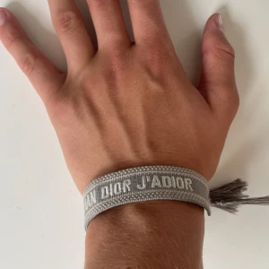 Dior armband  - Ett jätte snyggt och eftertraktat,  dior armband i storlek one size. Armbandet är äkta men har tyvärr inte bevis på det. Köpt i Köpenhamn  för 2799. Armbandet är ett flätat lätt armband, som är perfekt för att lyxa till och göra din outfit snyggare. Armbandet har en enstaka defekt. Den ena tofsen är halvt av, men syns inte alls vid användning. Priset är diskuterbart, skriv ifall ni har frågor! 