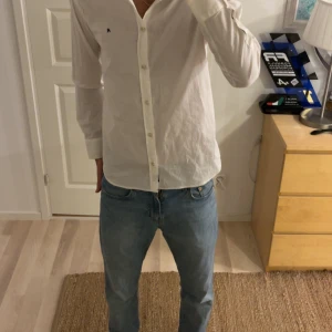 Vit skjorta från Replay med knappar - Klassisk vit skjorta från Replay med lång ärm och knäppning framtill. Skjortan har en liten broderad R-logga på bröstet och är tillverkad i mjuk bomull. Perfekt för dig som gillar en clean och stilren look.