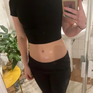 Svart croppad topp med kort ärm - En svart, croppad topp. Sitter tajt och är rätt så kort. Storlek S och är använd fåtal gånger och inga defekter 