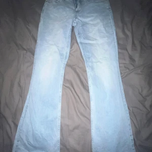 Ljusblå bootcut jeans från C Denim - Säljer ett par ljusblå jeans från C Denim i klassisk bootcut-modell. Jeansen har normal passform, fem fickor och dragkedja med knapp. Perfekta för dig som gillar retrovibbar och vill ha ett par riktigt snygga jeans i bomull.