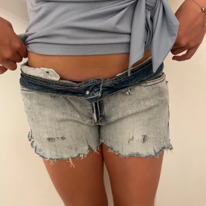 Ljusblå slitna jeansshorts - STORLEKEN ÄR BORTA MEN DEN ÄR SOM S-M Säljer ett par ljusblå jeansshorts med råa, fransiga kanter och slitningar för en riktigt avslappnad vibe. Shortsen har låg midja och klassisk femficksdesign. Perfekta för varma dagar när du vill ha en cool och chill look. 🌸