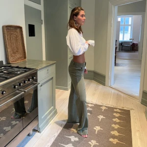 Olivgröna bootcut byxor - Design by si byxor. Orginalpris: 605kr. Snygga olivgröna byxor med bootcut-snitt och låg midja. Byxorna har klassiska fickor fram och bak samt bälteshällor. Perfekta för dig som gillar en avslappnad men trendig look.