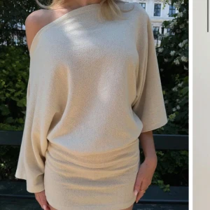 Beige offshoulder kortklänning slutsåld - Superfin beige kortklänning med offshoulder och vida trekvartsärmar. Klänningen har en loose fit upptill och tightare kjol, kjolen är helt slutsåld på Nellys hemsida, använd en gång.