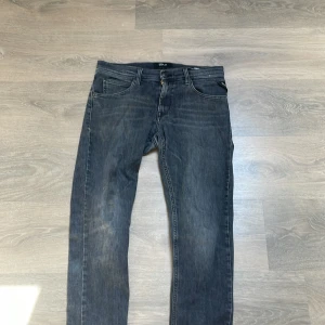 Replay svarta jeans med raka ben - Säljer ett par svarta Replay jeans med snygg tvätt och klassiska bakfickor med broderad detalj. Jeansen har raka ben och normal passform, tillverkade i mjukt jeanstyg som sitter skönt hela dagen. Perfekta för dig som gillar stilrena och tidlösa jeans.