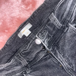 Svarta jeans från Gina Tricot bootcut - Snygga svarta jeans från Gina Tricot i storlek 152. Jeansen har klassisk femficksdesign, dragkedja och knapp framtill samt bootcut-ben. Materialet är jeans med en lätt tvättad look som ger en cool vibe.