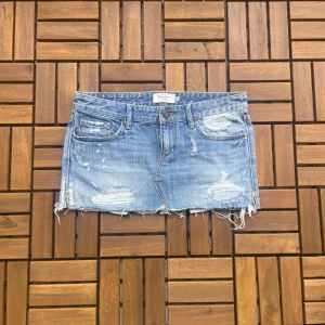 Abercrombie & Fitch jeanskjol - Säljer denna super snygga jeanskjolen från Abercrombie & Fitch då den inte passade, annars hade jag behållt den själv:( alla mått finns på bilderna och jag kan inte skicka bilder med kjolen på då den inte passar! 💗💗💗 även om midjemåttet är runt 40 cm så är den liten i storleken och är mellan xs och s!🥰