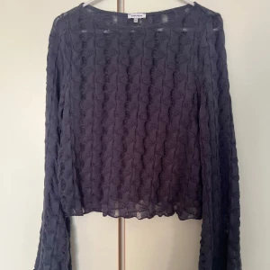 Blå långärmad tröja - Säljer en blå långärmad tröja från Bubbleroom med vågigt strukturmönster. Toppen har långa, vida ärmar och är tillverkad i tunn. Perfekt för lager-på-lager och en cool, edgy look.