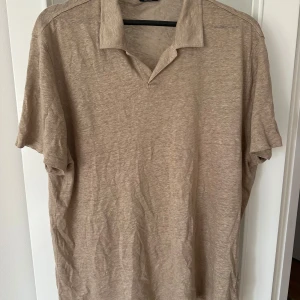 Beige linneskjorta från Massimo Dutti - Säljer en stilren beige skjorta från Massimo Dutti i 100% linne. Skjortan har korta ärmar och en klassisk krage, perfekt för varma dagar. Den är både bekväm och luftig, vilket gör den idealisk för sommarens alla tillfällen. Köpt men aldrig använd. 