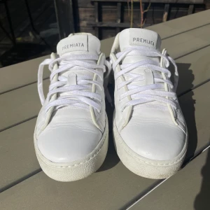 Premieta skor - Snygga vita skor från Premiata, riktigt sköna skor inför sommaren. Skon är storlek 42 men skulle kunna passa 41. Skorna har inga defekter alls, bara lite smuts som enkelt går bort vid tvätt. Priset är inte hugget i sten.