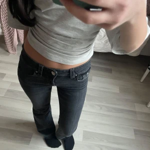 Lågmidjade bootcut jeans - Ett par jättefina svara/mörkgrå bootcut lowwaist jeans. Har sprettat upp sömmen längst ned för ett par extra centimeter men det är faktiskt ganska fint. Midja:33cm innerbenslängd: 70cm