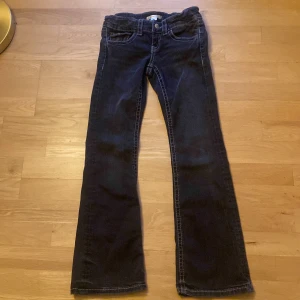 Mörkblå bootcut jeans - Snygga mörkgrå bootcut jeans med klassisk femficksdesign. De har en bekväm passform och är perfekta för en avslappnad stil. Jeansen har en dragkedja och knapp framtill.