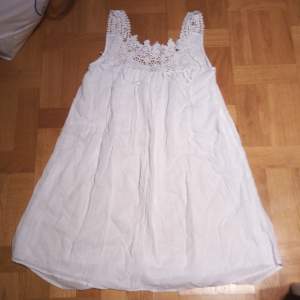 Säljer en söt vit klänning från Vero Moda med vackra spetsdetaljer vid axelbanden och halsringningen. Klänningen är ärmlös och har en luftig passform, perfekt för varma dagar. Den är gjord i ett lätt och bekvämt material.